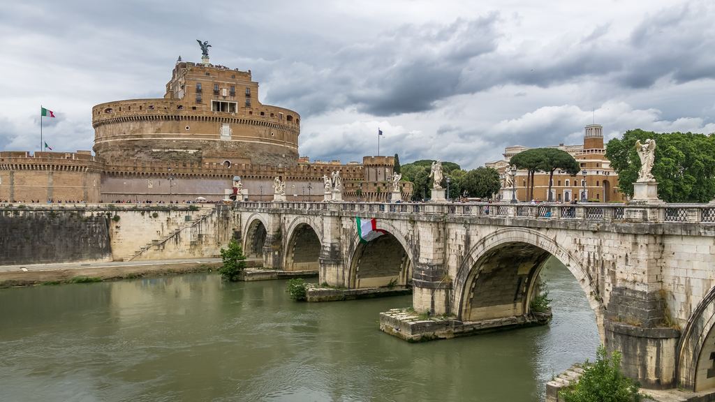 Castel Sant'Angelo and the statues of the Ponte Sant'Angelo seen across the Tiber under a sky of heavy cloud.