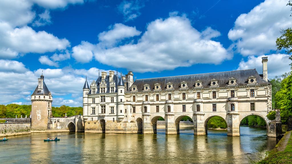 The Chateau de Chenonceau and its arched gallery carried across the river Cher on a clear day.