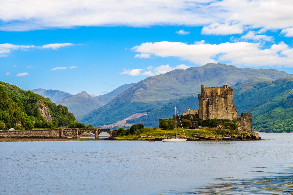 Eilean Donan Castle on its small island where three sea lochs meet, with Highland peaks rising behind.