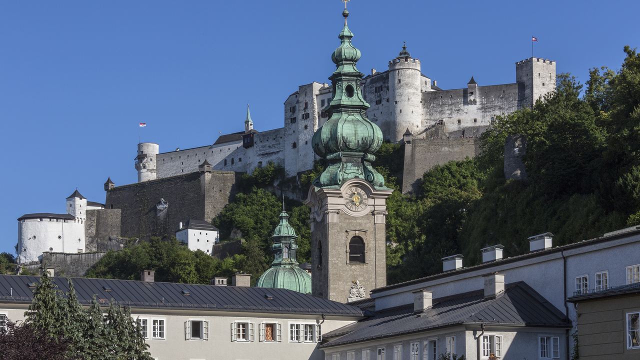 The Hohensalzburg fortress on its wooded ridge above the domes and roofs of the old town of Salzburg.
