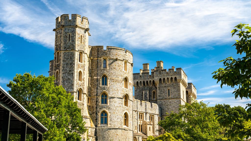 The battlemented King Edward III Tower on the outer wall of Windsor Castle against a blue sky.
