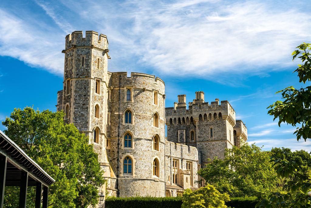 The battlemented King Edward III Tower on the outer wall of Windsor Castle against a blue sky.
