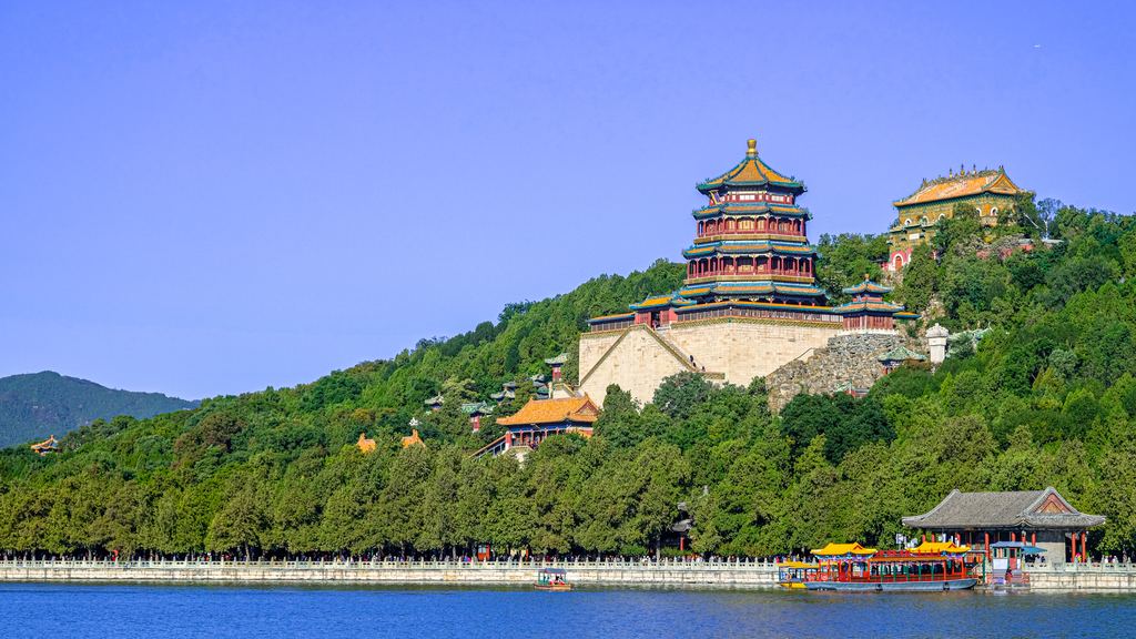 The Tower of Buddhist Incense rising on Longevity Hill above a wooded slope and the blue water of Kunming Lake.