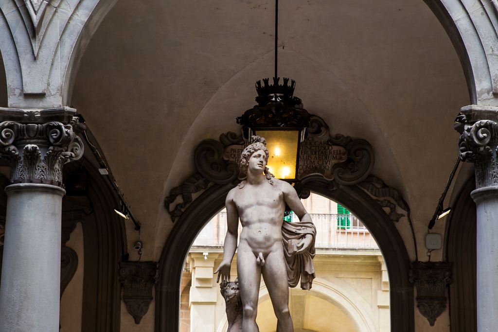Bandinelli's marble Orpheus standing on its pedestal beneath the arches of the Medici Riccardi courtyard in Florence.