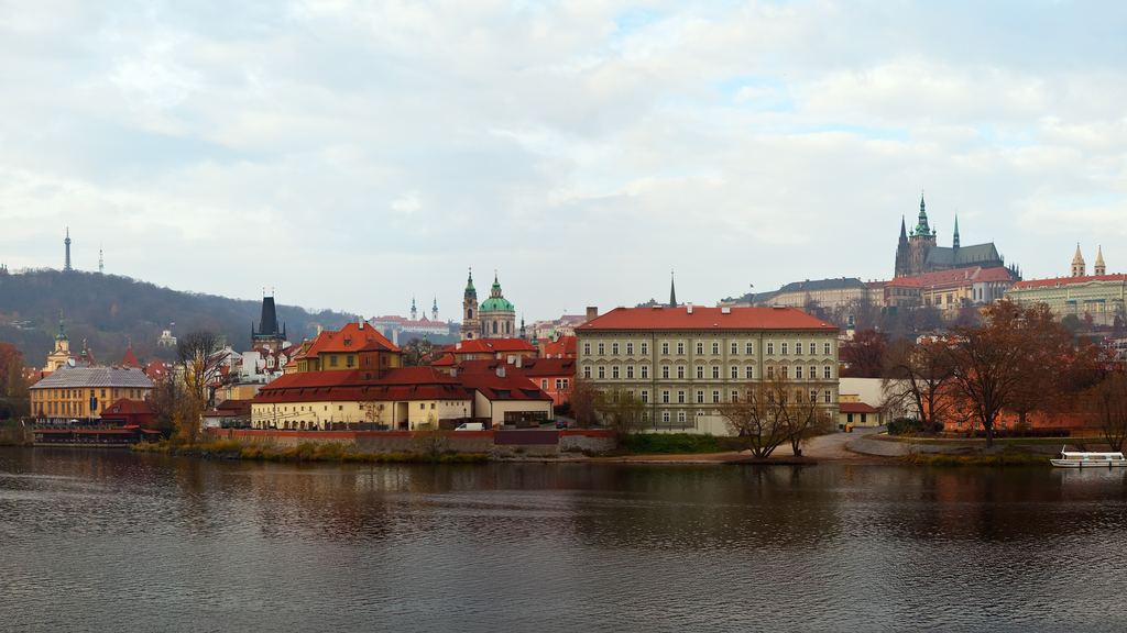 A wide view of Prague along the Vltava, with the castle and the spires of St Vitus standing on the ridge above the city.