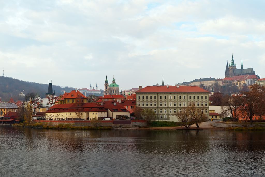 A wide view of Prague along the Vltava, with the castle and the spires of St Vitus standing on the ridge above the city.
