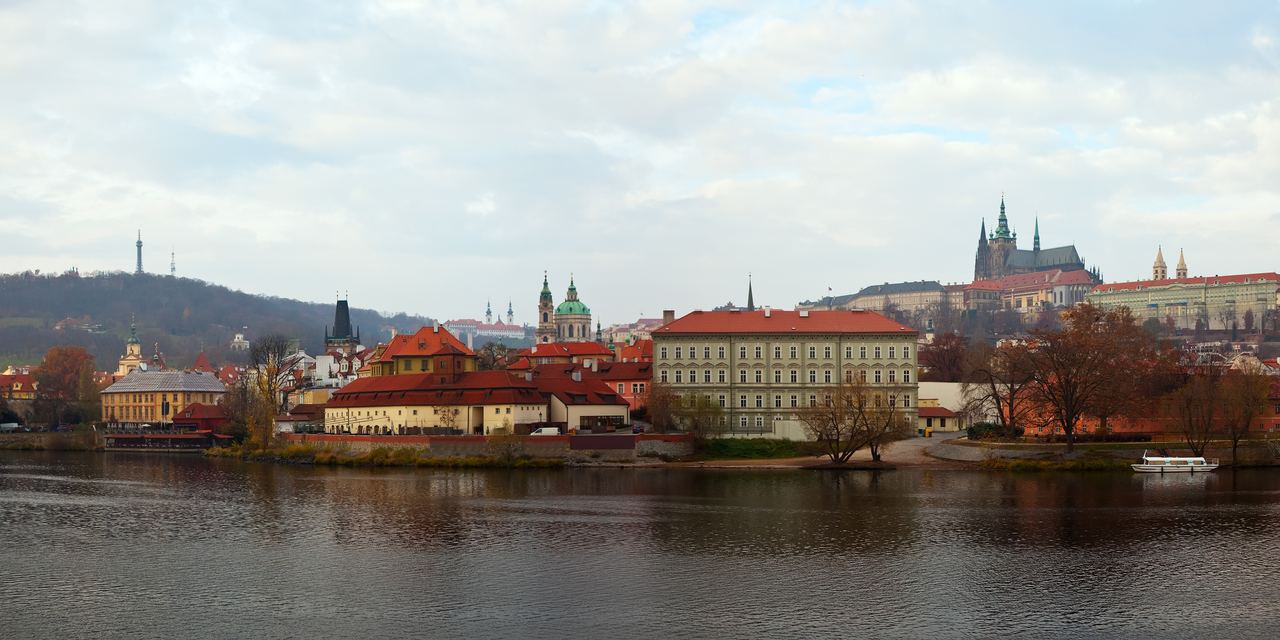 A wide view of Prague along the Vltava, with the castle and the spires of St Vitus standing on the ridge above the city.