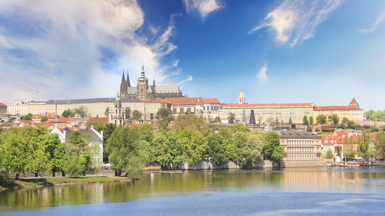 Prague Castle and the spires of St Vitus Cathedral standing above the roofs of Mala Strana and the Vltava river.