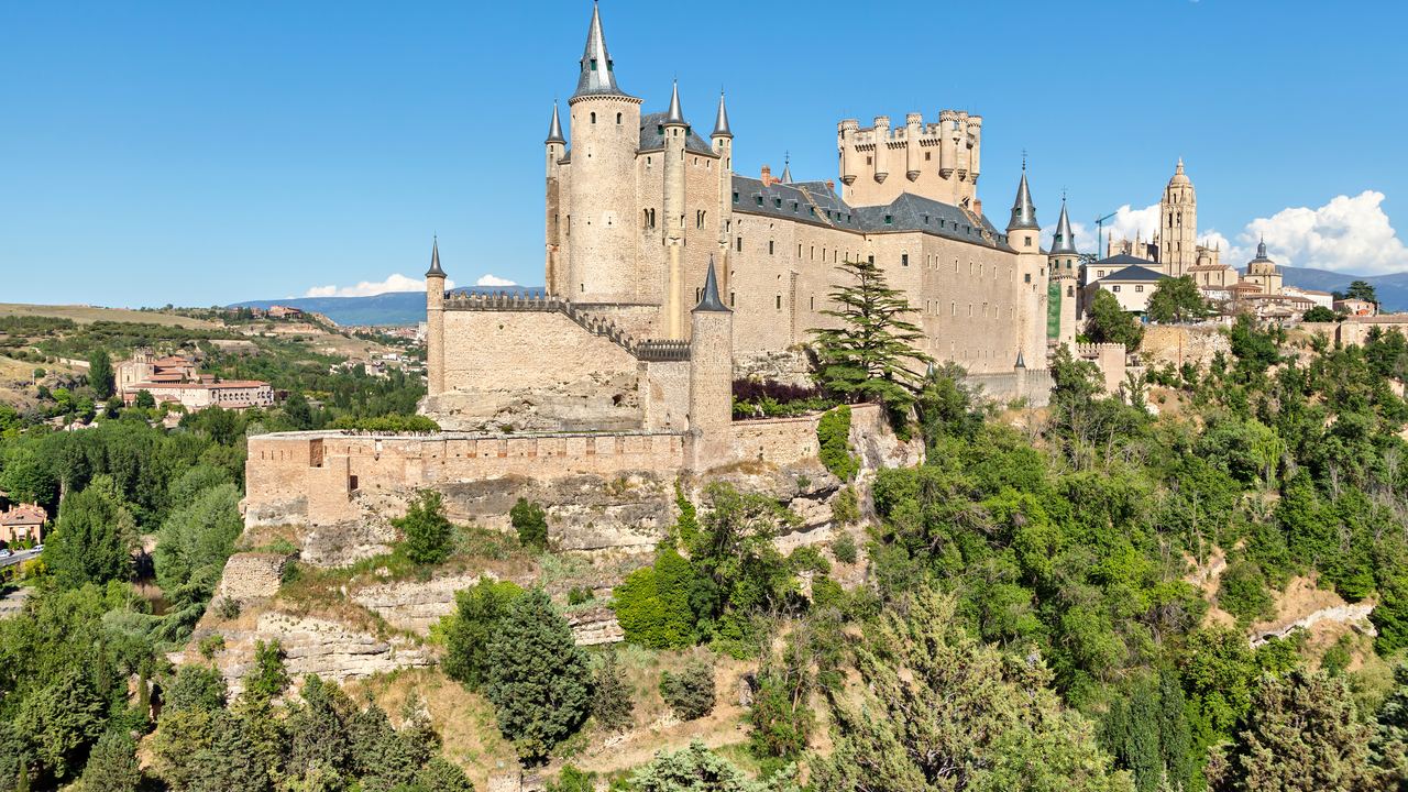 The Alcazar of Segovia standing on the wooded rock spur above the Castilian plain.