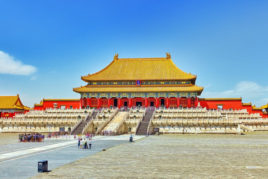 A great golden-roofed hall of the Forbidden City standing on its marble terrace across an empty stone courtyard.