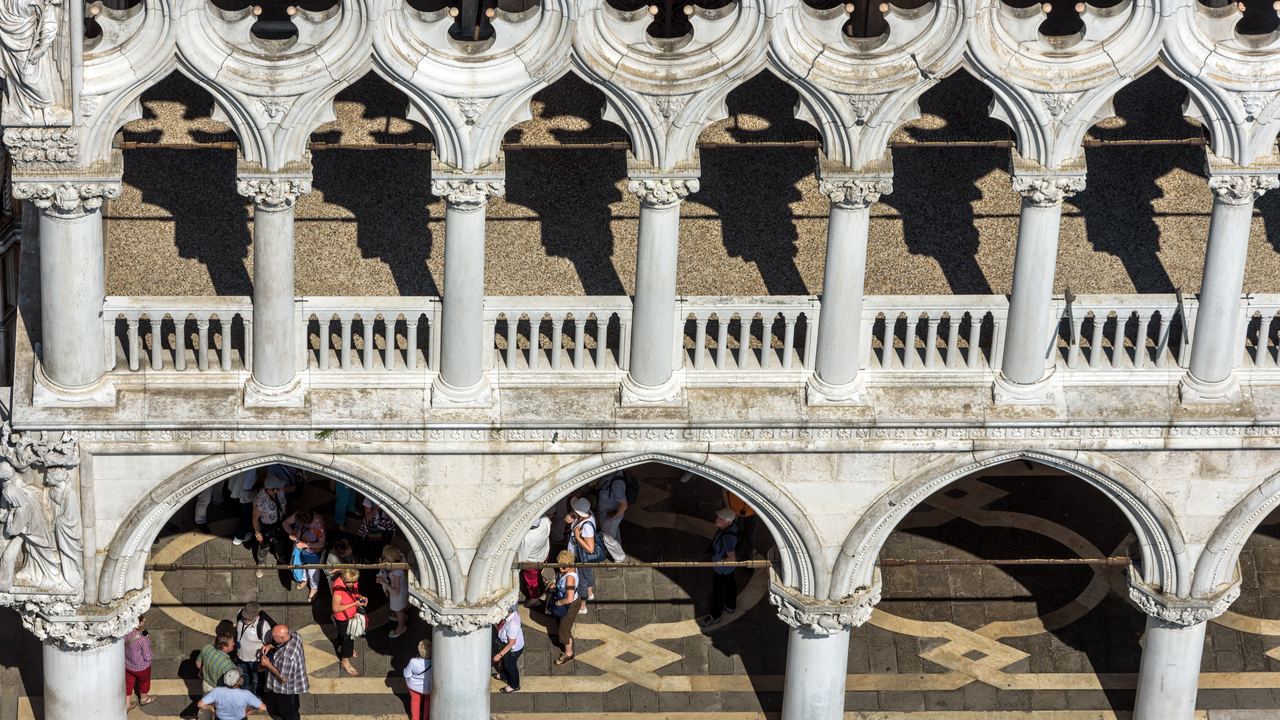 The carved stone tracery and arcade of the Doge's Palace in Venice, seen close from the piazzetta below.