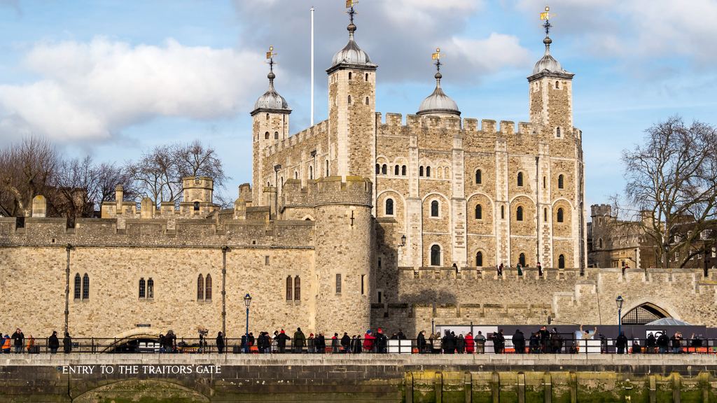 The White Tower and the riverside wall of the Tower of London seen from the bank of the Thames.